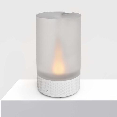 VOTIV 7 sitting on a white pedestal displaying tranquil flameless candlelight